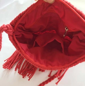 Detail view of the red woven bag interior showing zipper pocket and inner lining