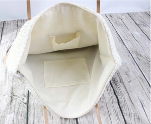 Interior view of straw tote bag showing beige lining with functional dual inner pockets