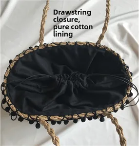 Detail of straw tote bag showing black cotton lining and drawstring closure design