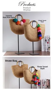 Detail view of woven straw handbags with colorful pompoms and decorative tassels