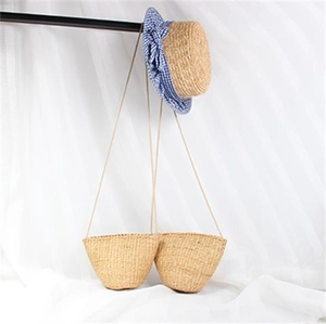 Détail du sac bandoulière en paille et chapeau de soleil avec nœud à carreaux bleus