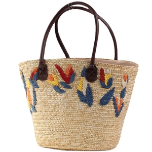 Handwoven straw tote bag with colorful leaf embroidery and brown leather handles for beach