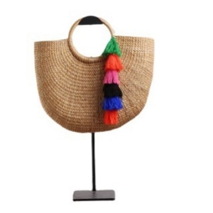 Handmade half-moon straw beach bag with vibrant colorful tassels and round top handle