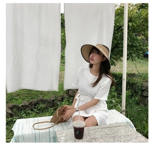 Detail of white short sleeve dress with vertical texture and matching waist tie belt