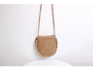 Detail of hand-woven straw crossbody bag with delicate hollowed-out scallop lace trim