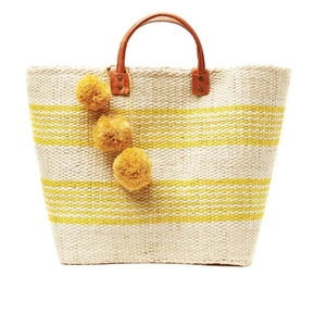 Handmade bohemian straw tote bag with yellow stripes and pompom charms for beach vacation