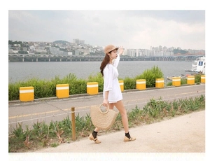 Detail of a round woven straw handbag with circular handles for summer beach vacations