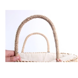 Detail of woven straw handles and cream cotton lining on a summer beach tote bag
