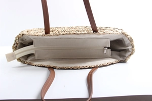 Detail of hand-woven straw tote bag showing durable inner lining and secure zipper closure