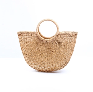 Detail of semi-circular straw bag showing radial woven texture and round top handle