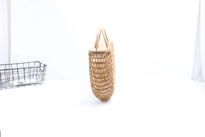 Detail view of woven rattan beach bag with hollow texture and inner drawstring liner