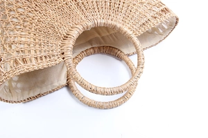 Detail view of the spacious inner lining and woven texture of the semi-circle straw bag