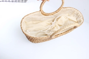 Top view of woven straw tote bag featuring cream fabric lining and secure drawstring closure