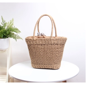 Detail of woven straw tote bag with polka dot scarf and breathable mesh pattern