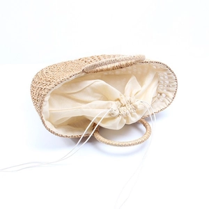 Handmade woven straw beach handbag with drawstring lining and round top handles