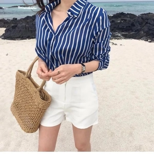Summer outfit featuring a blue striped shirt, white shorts, and a handmade straw beach bag
