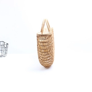 Handcrafted semicircular straw beach bag with hollow woven design and canvas lining