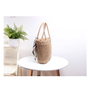 Handwoven straw tote bag with polka dot scarf and hollow mesh design for beach vacation