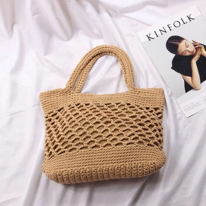 Detail of hand-woven straw bag with diamond hollow mesh and secure dark inner lining