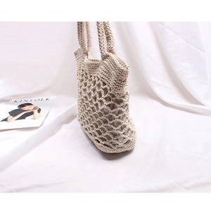 Detail showing hand-woven cotton mesh hollow structure of the cream beige beach bag