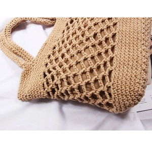 Detailed macro view of the handmade woven straw bag with hollow mesh and cotton lining