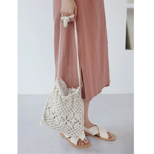 Handmade cream macrame crossbody bag with tassel detail and bohemian woven pattern