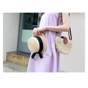 Straw hollow crossbody bag with leather flap shown with a lavender dress and straw hat