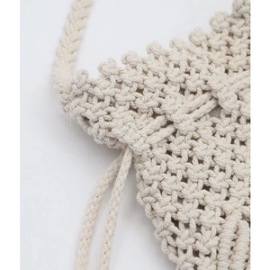 Macro view of beige handmade woven bag showing hollow mesh craft and drawstring closure