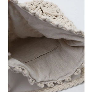Detail of handmade woven straw bag interior showing cream cotton lining and pocket