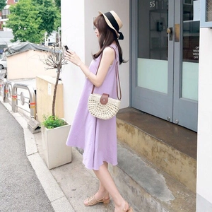 Detail view of a semi-circular woven straw crossbody bag styled with a summer outfit