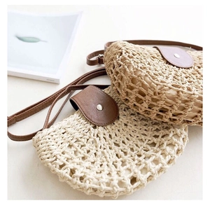 Detail of hollow woven straw crossbody bags with leather flap and mesh texture