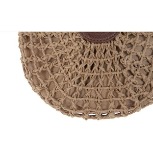 Close-up of bohemian straw bag featuring intricate cross-pattern weave and natural texture