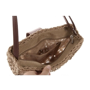 Close-up of handmade straw bag with polka dot lining and zip pocket detail
