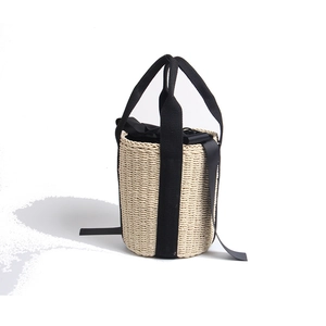 Handcrafted straw bucket bag with black ribbon handles for summer beach vacations