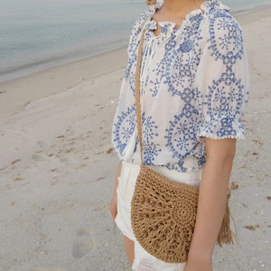 Handmade straw crossbody bag with fringe details for summer beach vacations