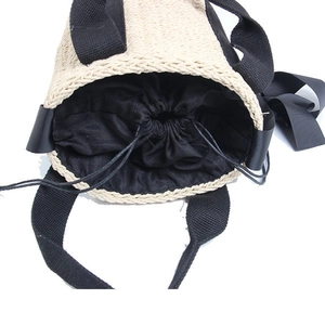 Woven straw bucket bag with black handles and drawstring liner for summer beach holidays