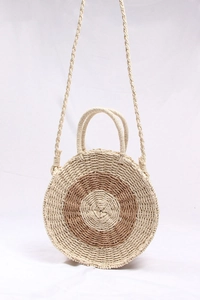 Detail of round straw bag showing the circular spiral weave and bicolor contrast