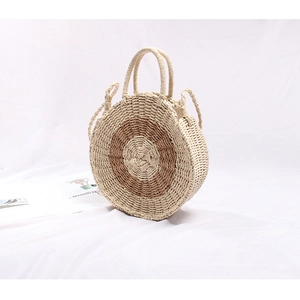 Detailed close-up of handmade straw round bag with two-tone circular woven texture