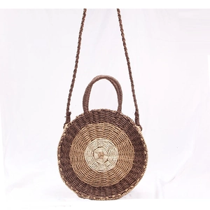 Detail of multi-tone round woven straw bag with concentric coffee and beige patterns