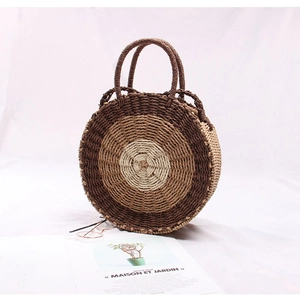 Detail of round straw bag showing concentric weave texture in beige and brown tones