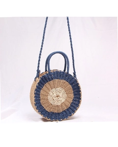 Detail of a round handmade woven straw bag with navy and wood dual-tone concentric pattern