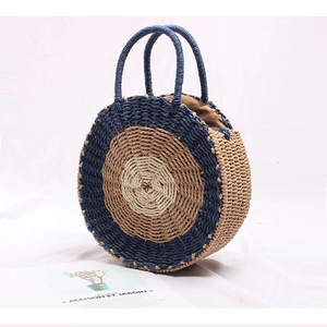 Detail of hand-woven round straw bag featuring a three-color concentric circle design