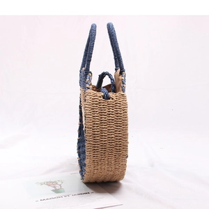 Detail of round straw bag showing blue trim, woven texture, and zipper closure
