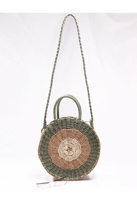 Detail of a round woven straw beach bag featuring a three-color concentric circle pattern