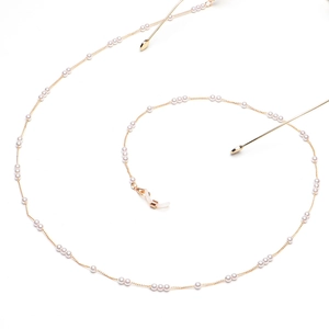 Detailed view of pearl eyewear chain with fine gold links and silicone anti-slip loops
