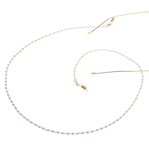 Detail of elegant gold glasses chain with white pearls and anti-slip silicone loops
