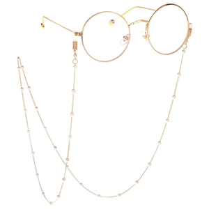 Detail view of gold round glasses with elegant white pearl decorative eyewear chain
