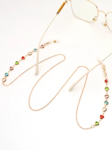 Détail d'une chaîne à lunettes dorée avec breloques cœurs colorés et attaches