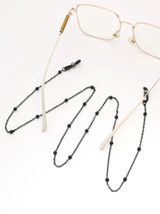 Détail de la chaîne de lunettes à perles noires montrant l'attache en silicone au cadre