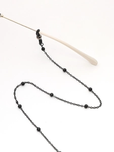 Détail d'une chaîne de lunettes à perles noires avec maillons et boucles en caoutchouc